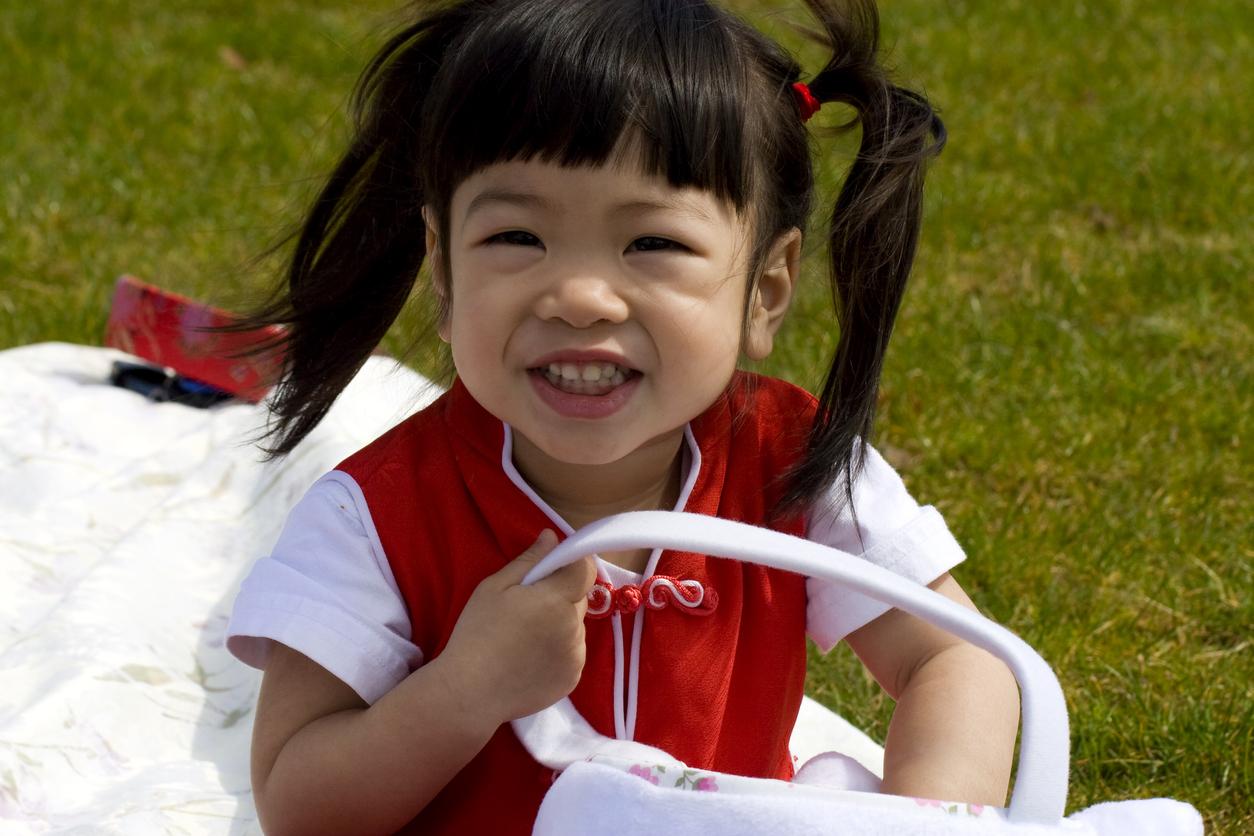 Adorable Asian Baby Girl at Easter Egg Hunt Outside, Copyspace