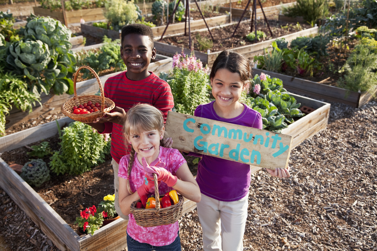 Children holding community garden sign