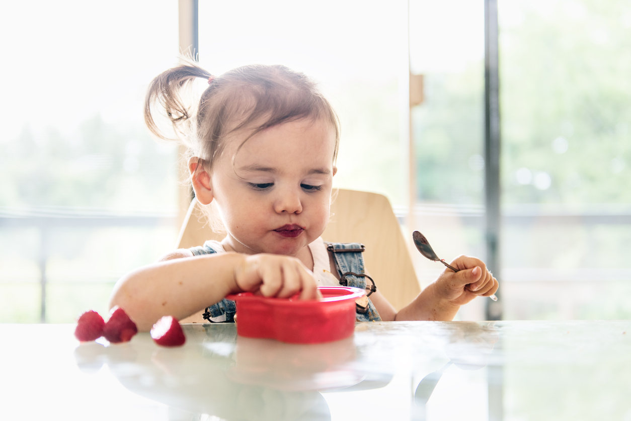 Little 2 years old girl eating jello