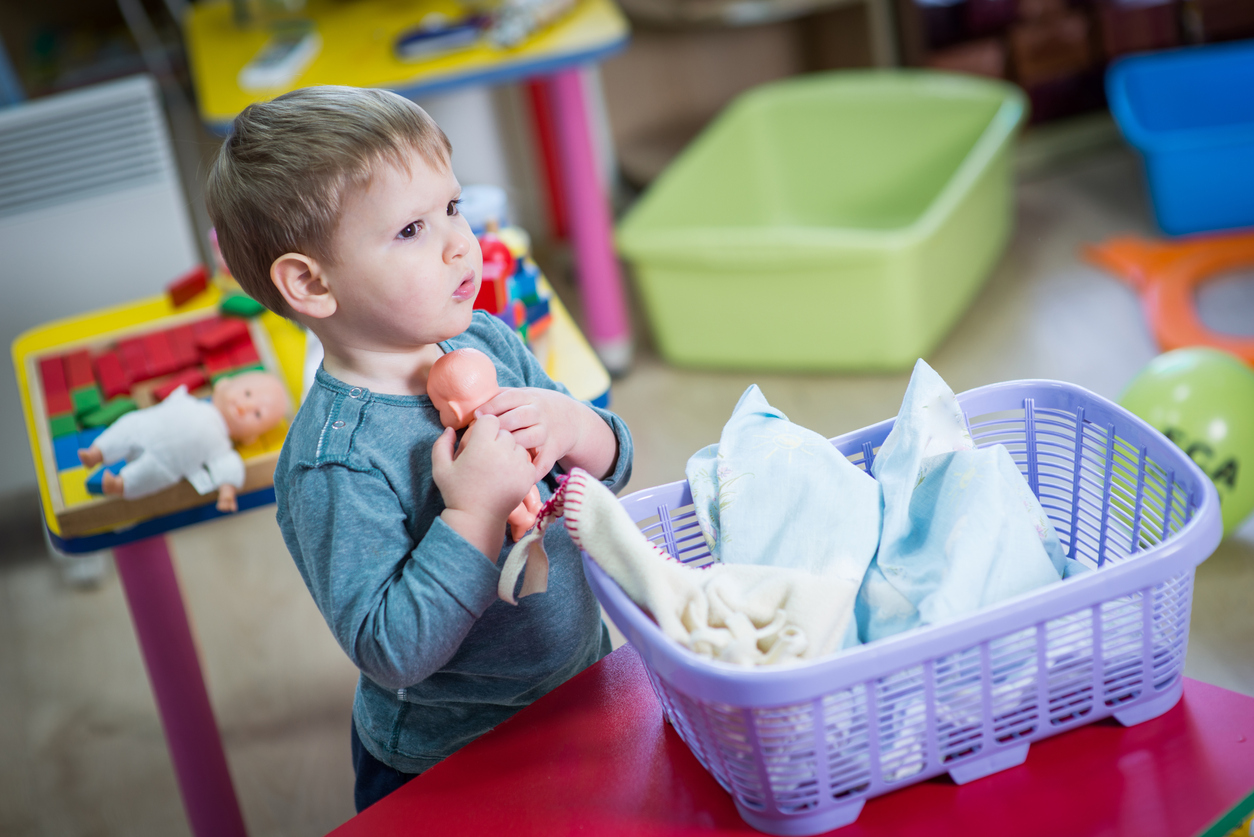 Little boy plays with a doll
