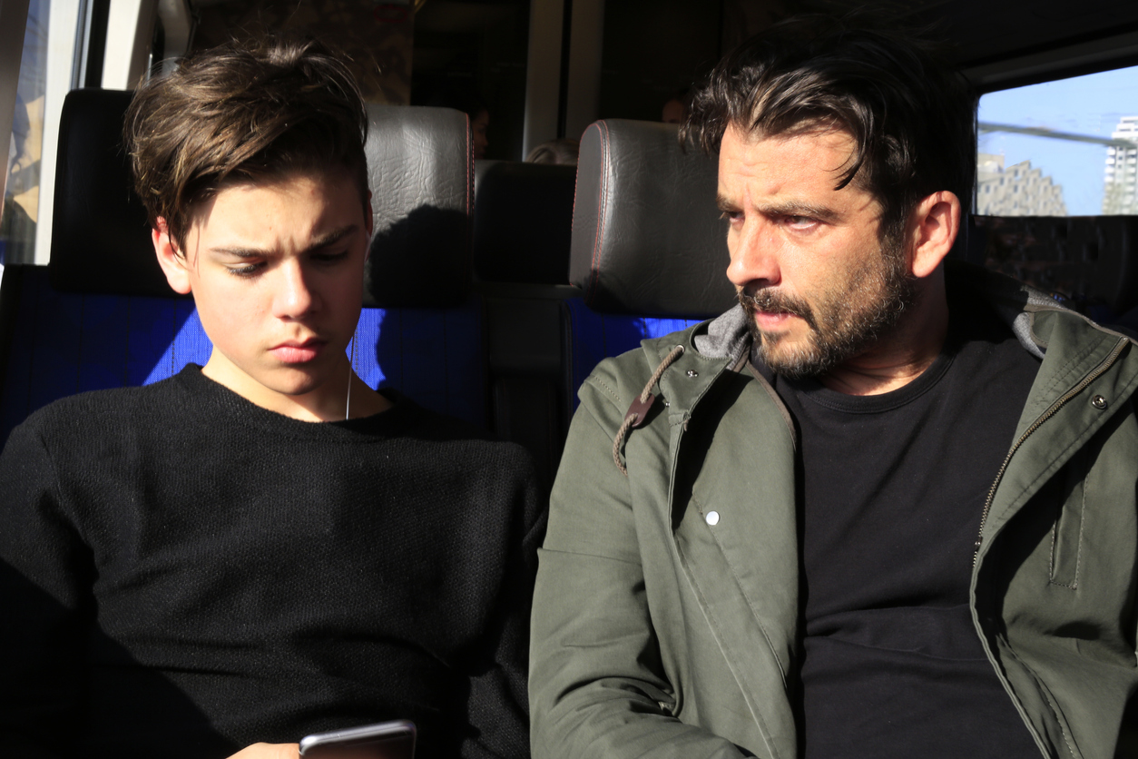 Father and teenage son traveling with train