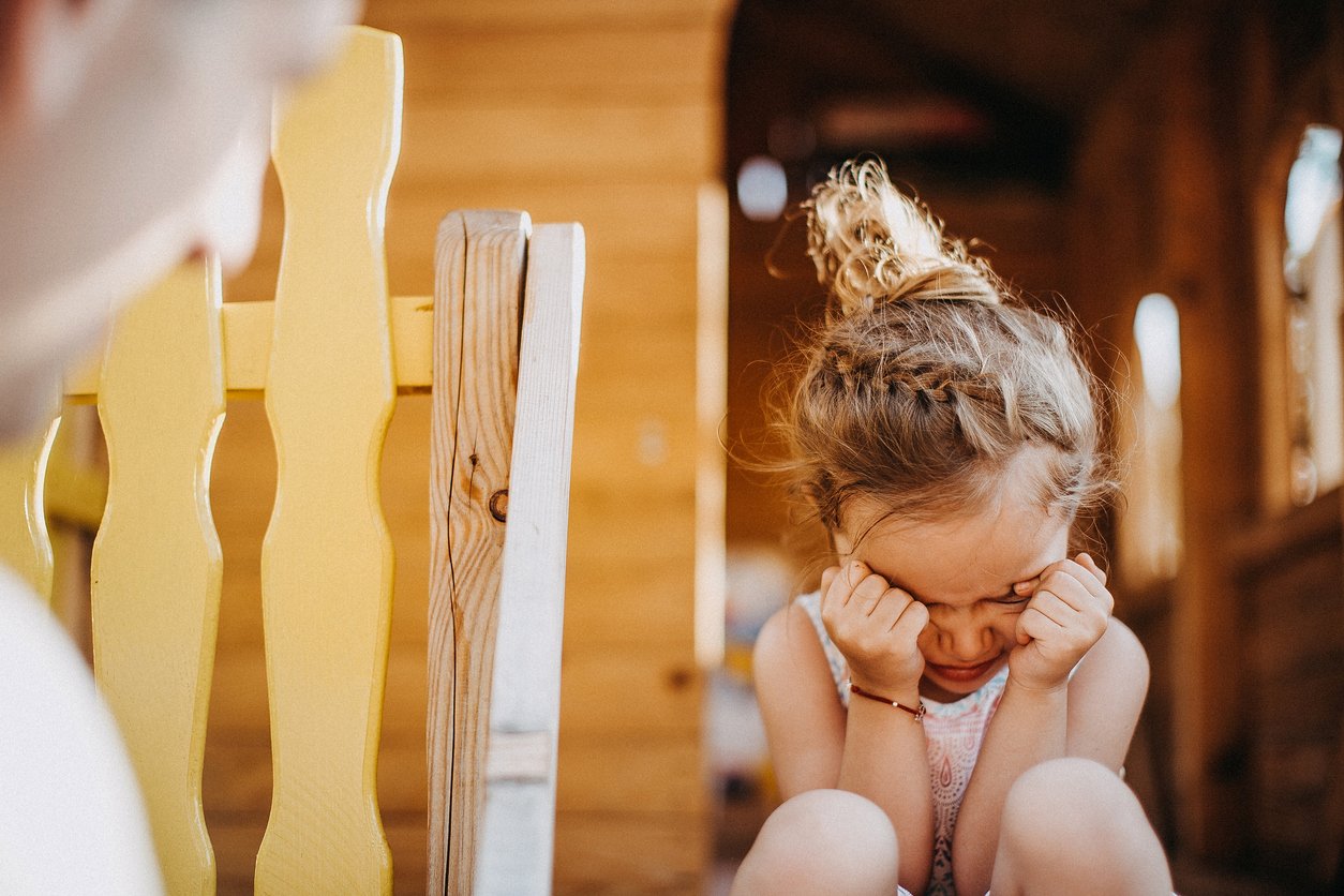 Little girl playing on playground and crying