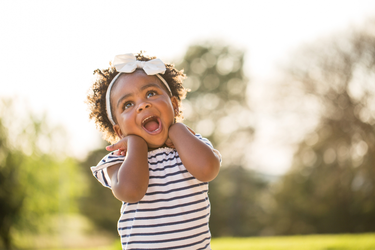 Happy little girl laughing and smiling outside.