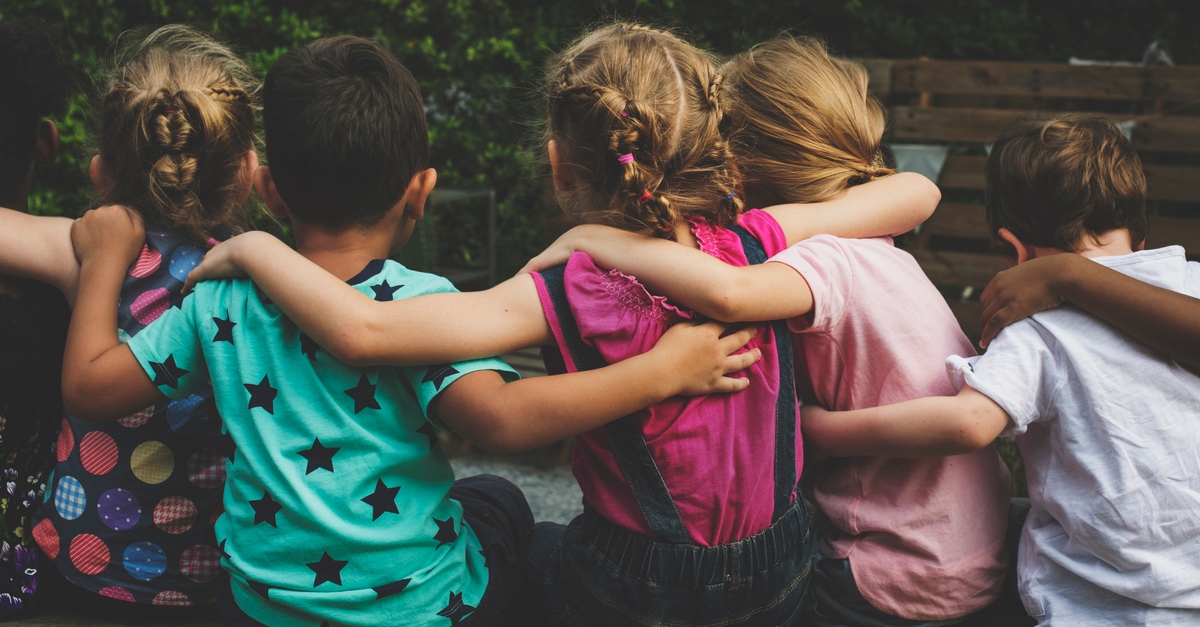 Group of kindergarten kids friends arm around sitting together