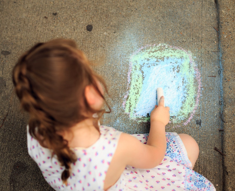 little-girl-drawing-on-pavement-with-colored-chalk-2414839.jpg