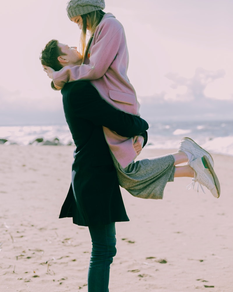 man-in-gray-coat-carrying-woman-wearing-pink-coat-in-beach-698885.jpg