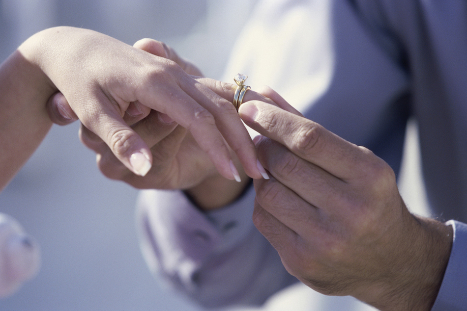Close-up of a man putting a ring on a woman's finger