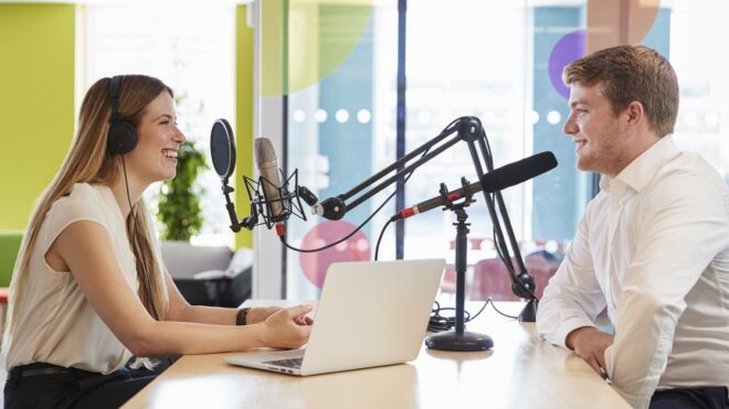 Young woman interviewing a guest in a studio for a podcast