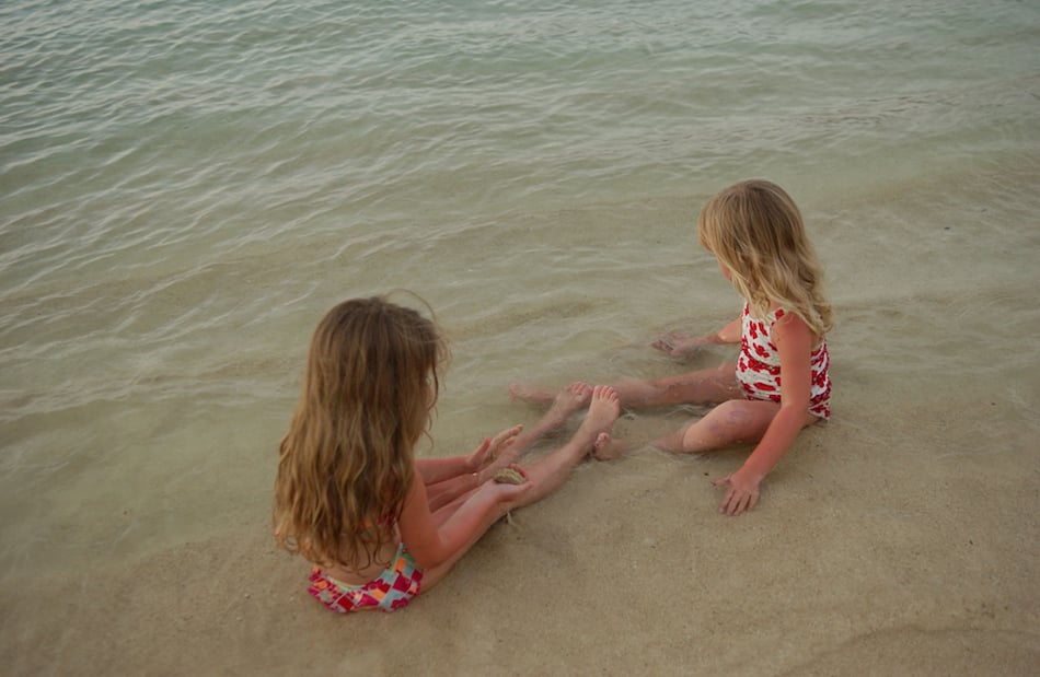 Two young girls (6-8) playing in water, Moorea, Tahiti, French Polynesia, South Pacific