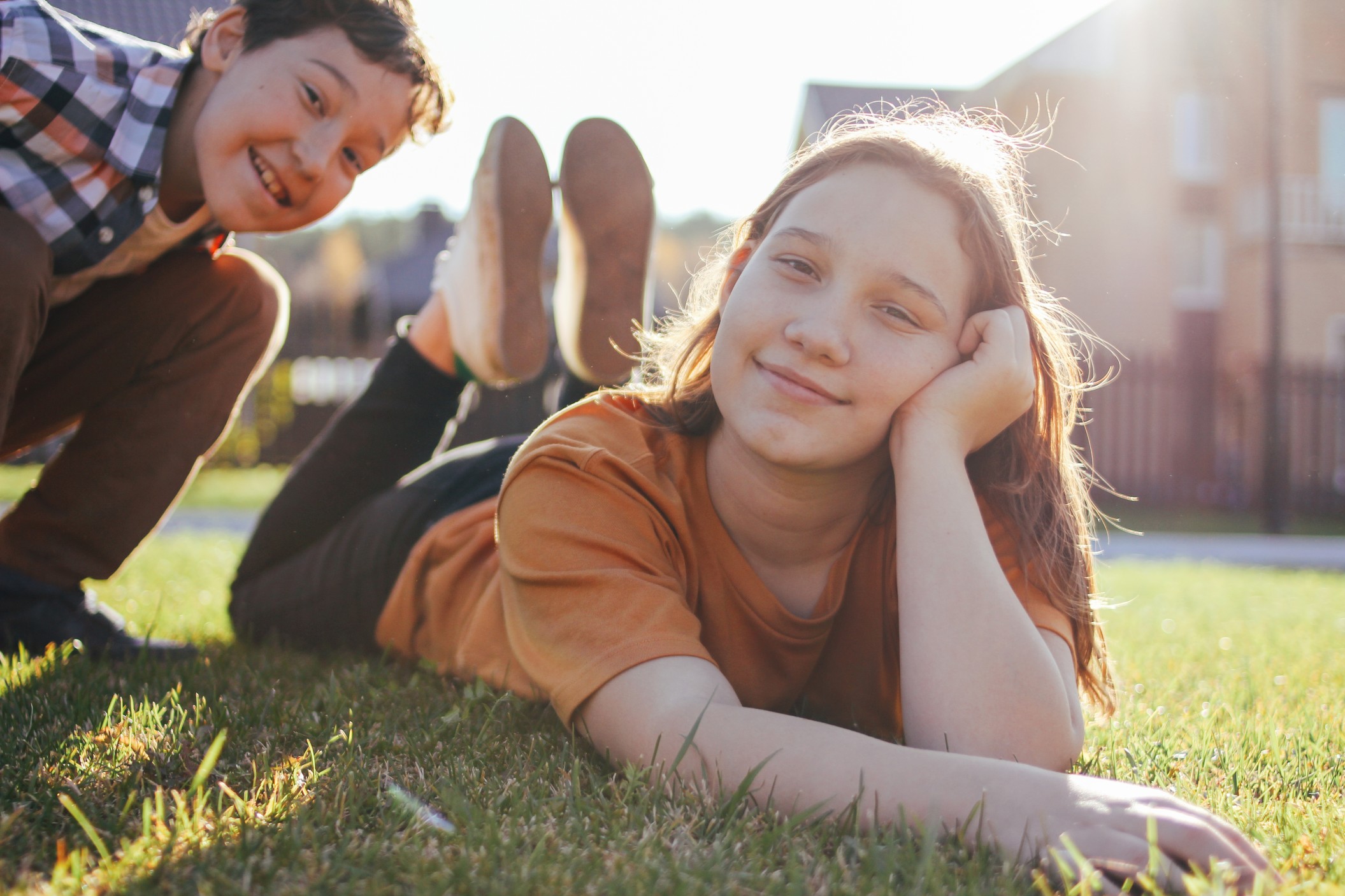 smiling-children-brother-and-sister-lying-on-sunny-green-grass-of-cottage-village-on-the-background_t20_3Qko8N.jpg