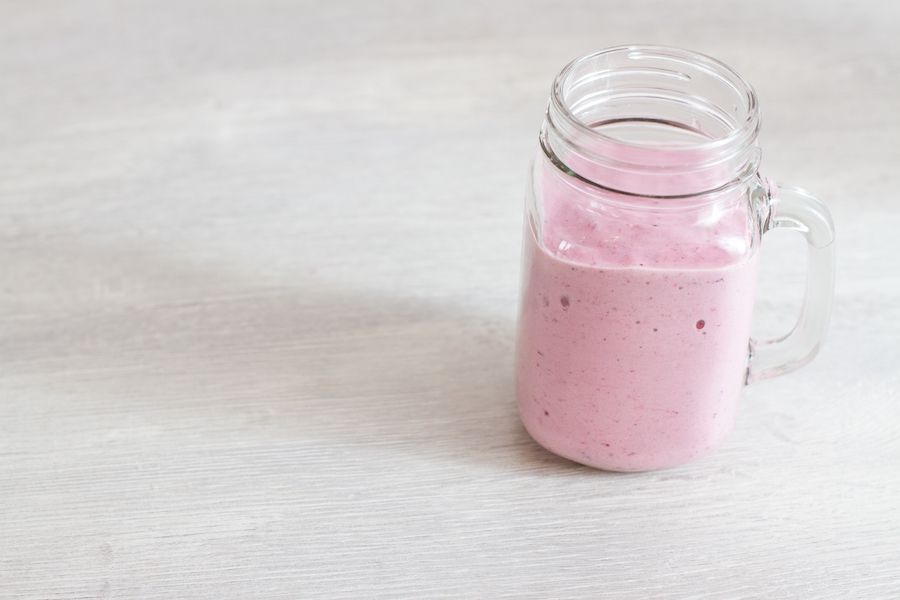 Strawberry smoothie or milkshake in mason jar mug. Healthy food on kitchen white backgroound