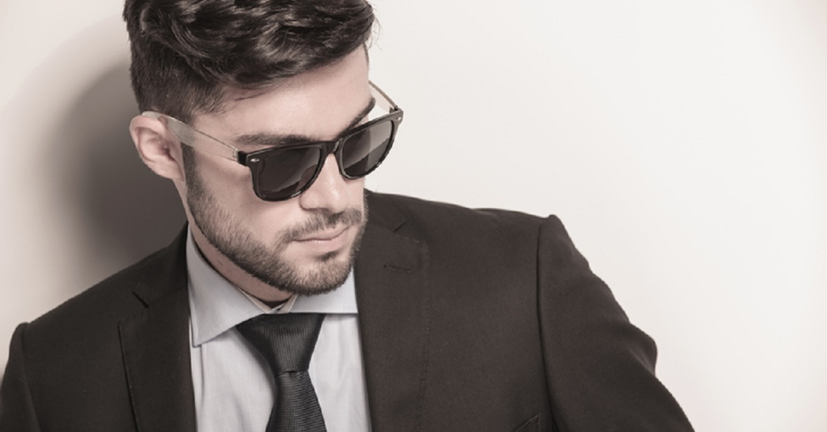 sexy young business man wearing sunglasses looks away