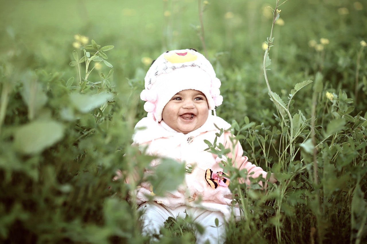 toddler-wearing-whit-cap-on-green-field-803277.jpg