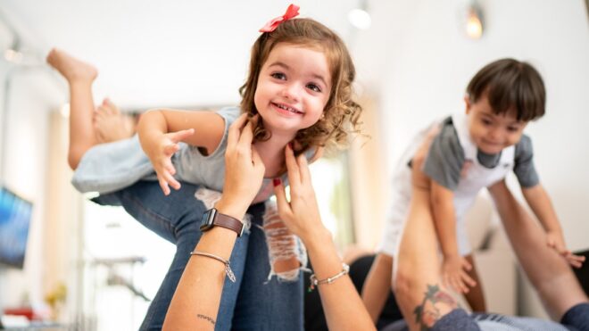 Parents picking up twin sibling (Down Syndrome Boy and Girl)