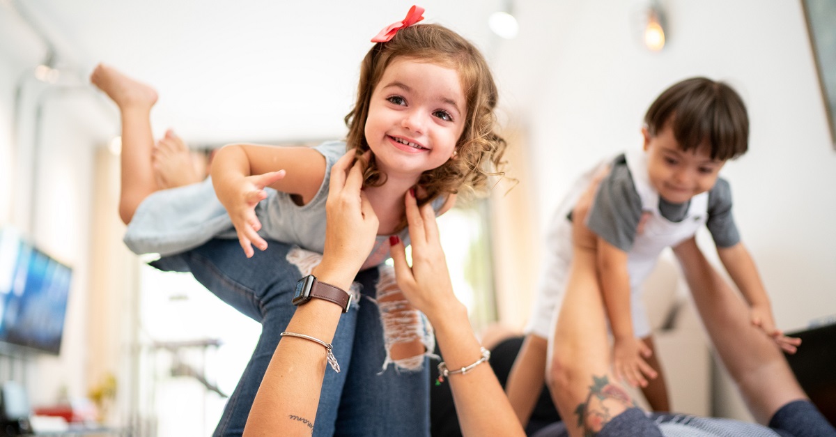 Parents picking up twin sibling (Down Syndrome Boy and Girl)