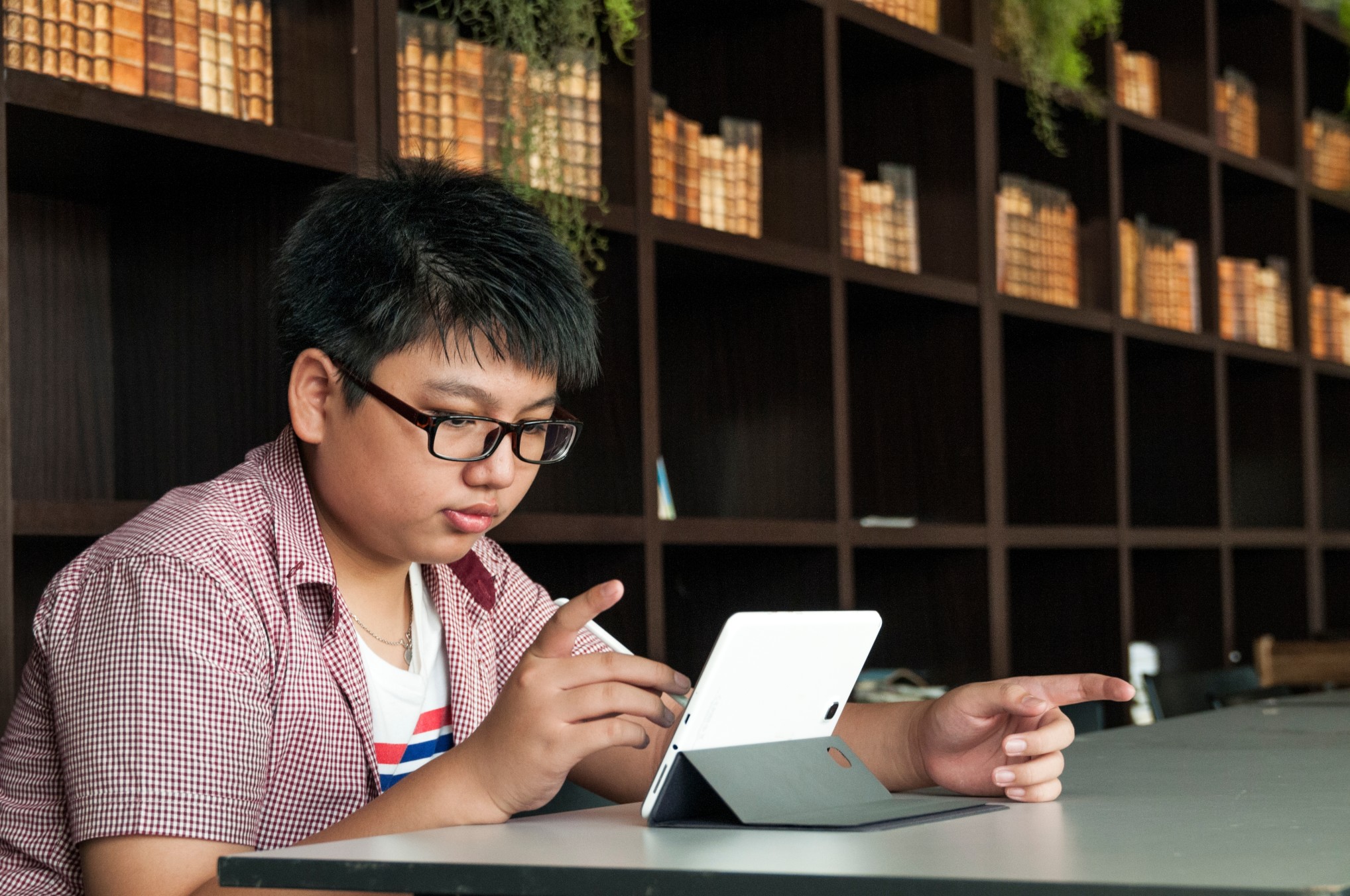 tween-kid-using-mobile-device-in-library_t20_knLzKP.jpg