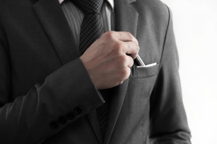 Businessman picking a pen from the pocket.