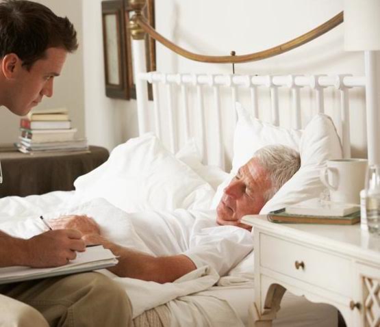 Doctor Talking With Senior Male Patient In Bed