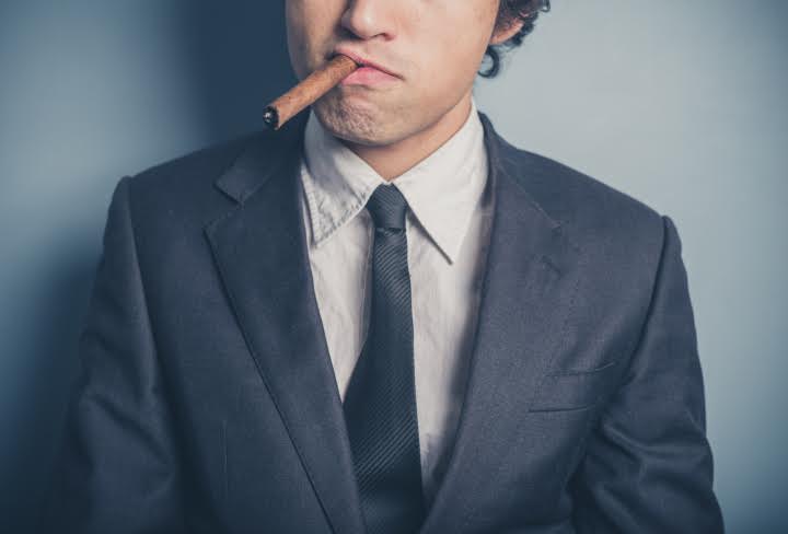 Young businessman smoking a cigar