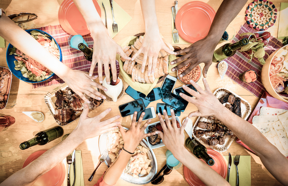 Top view of friend hands with mobile smartphones on food