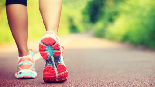 Young fitness female runner legs ready for run on forest trail