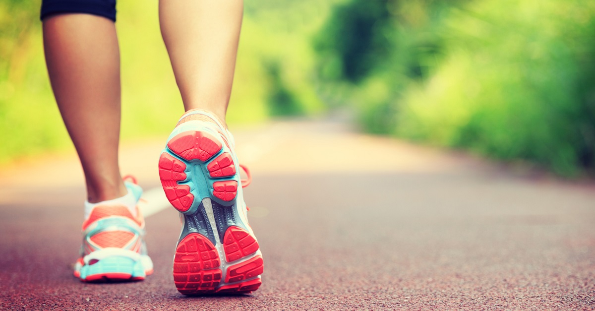 Young fitness female runner legs ready for run on forest trail