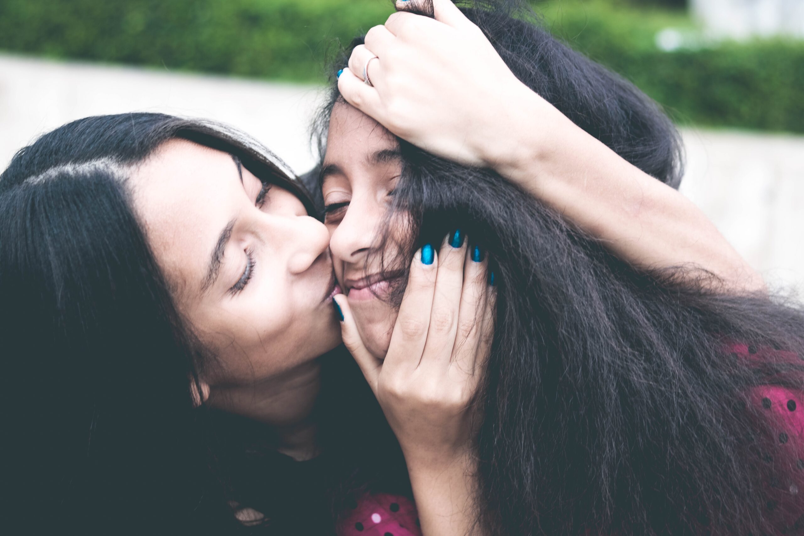 woman-kissing-cheek-of-girl-wearing-red-and-black-polka-dot-1101730.jpg