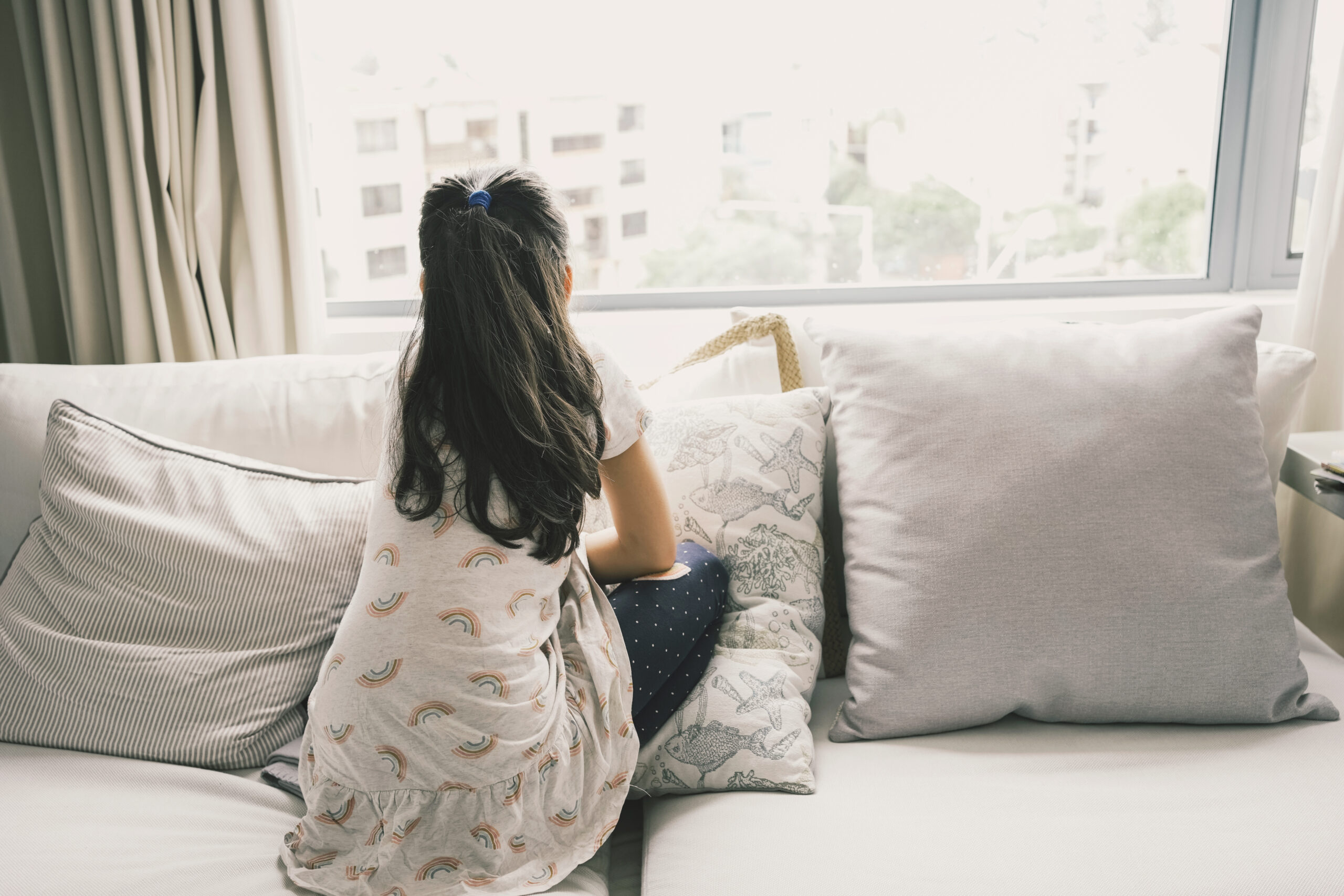 Depressed tween girl looking out window, child mental health, stop bullying, kid autism awareness concept