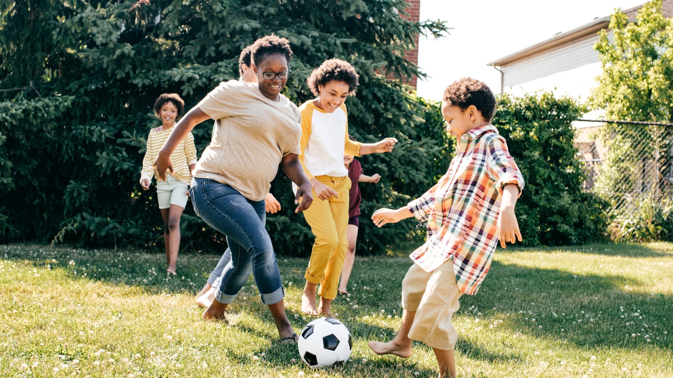 Family playing soccer in their backyard