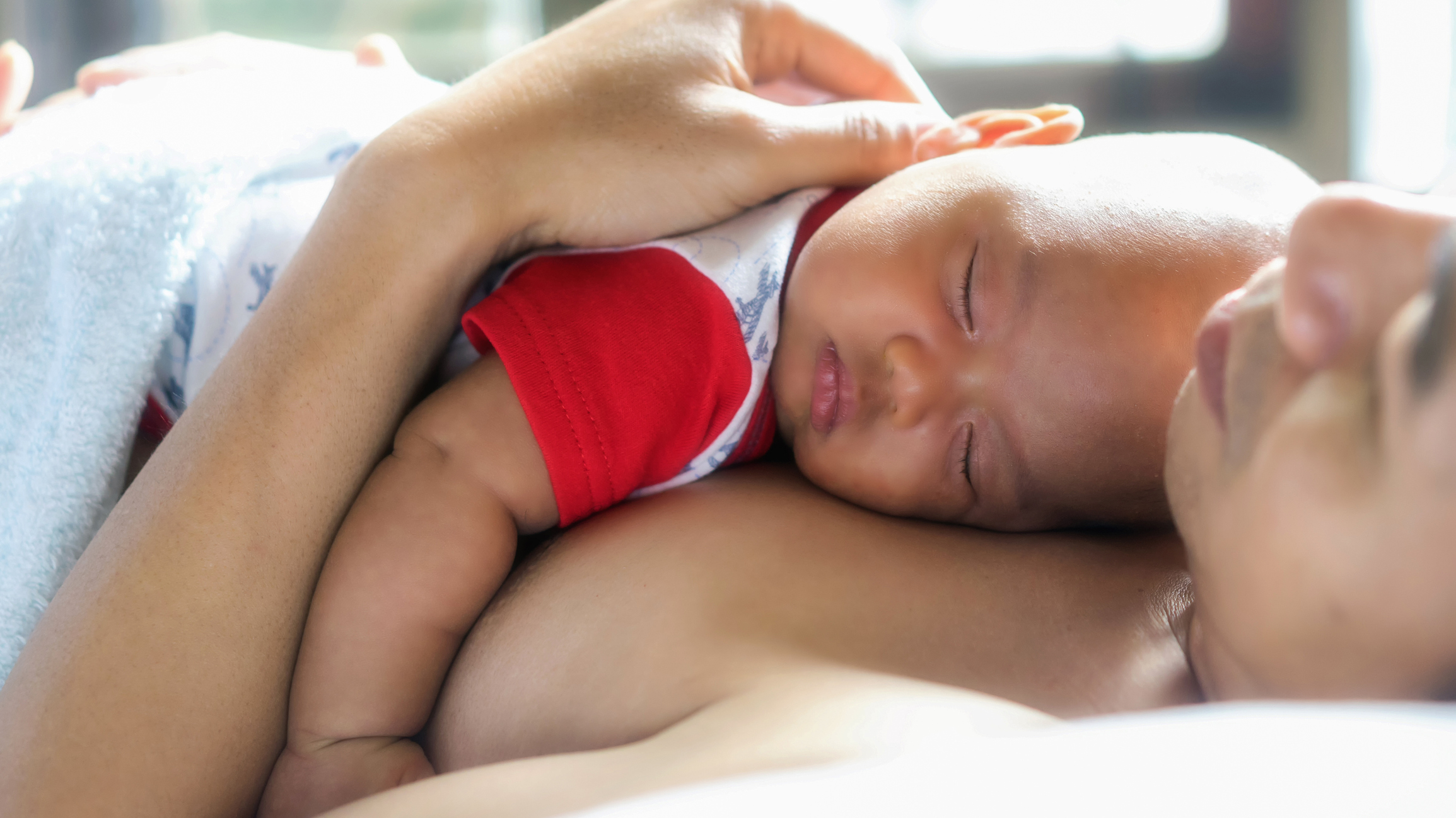 The Newborn baby sleeping on father's chest. Co-sleeping father and baby child; soft amd select focus