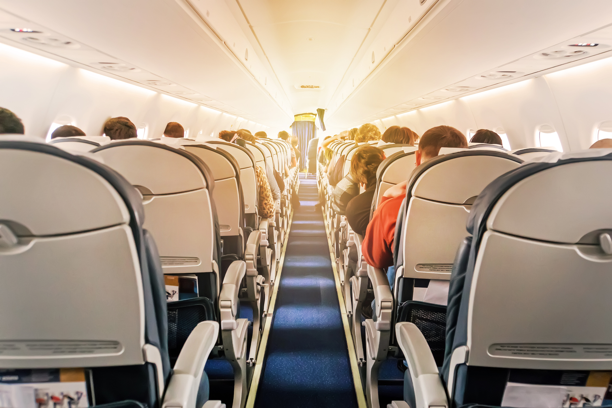 Commercial aircraft cabin with rows of seats down the aisle