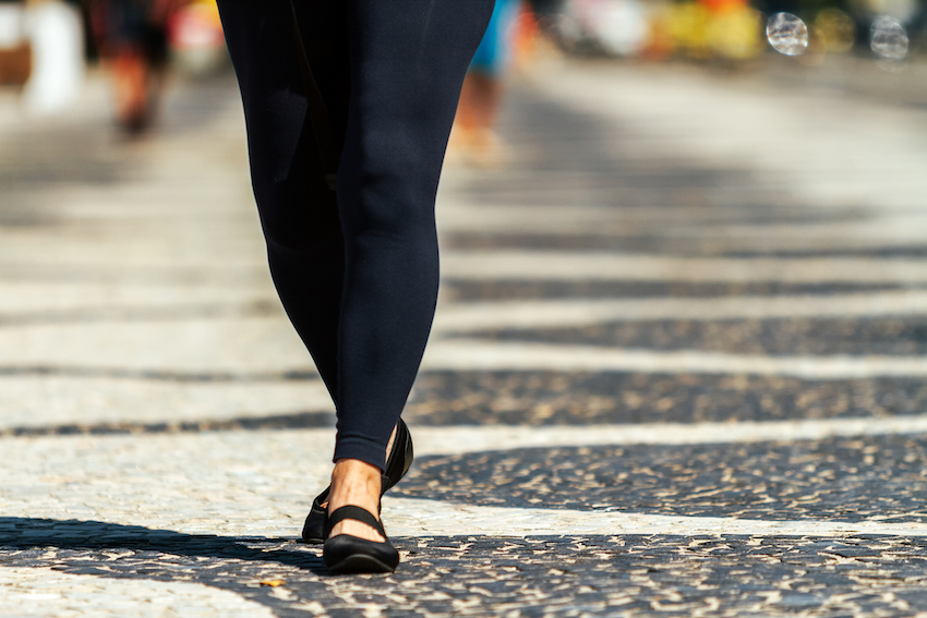 Close-up of legs of middle-aged woman walking on a Copacabana sidewalk in Rio de Janeiro, Brazil