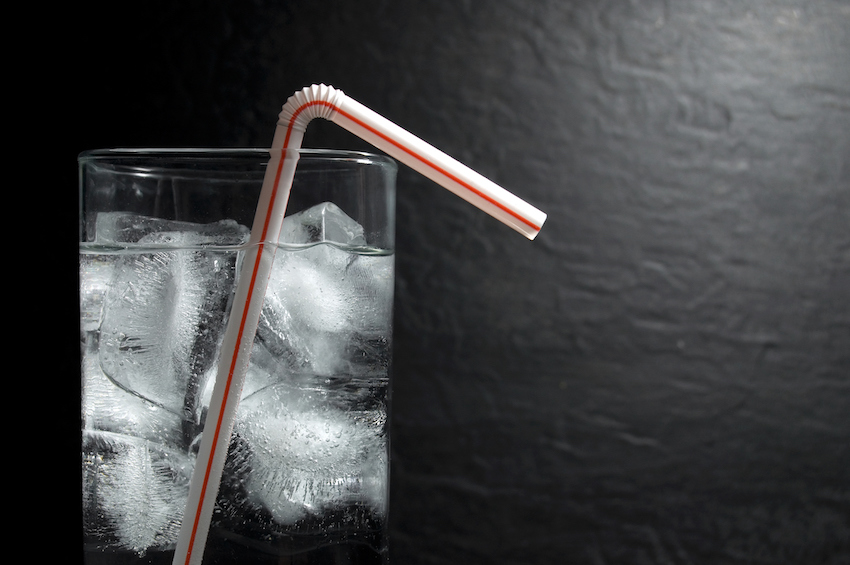 Glass of Natural Water with Ice and Plastic Red and White Straw