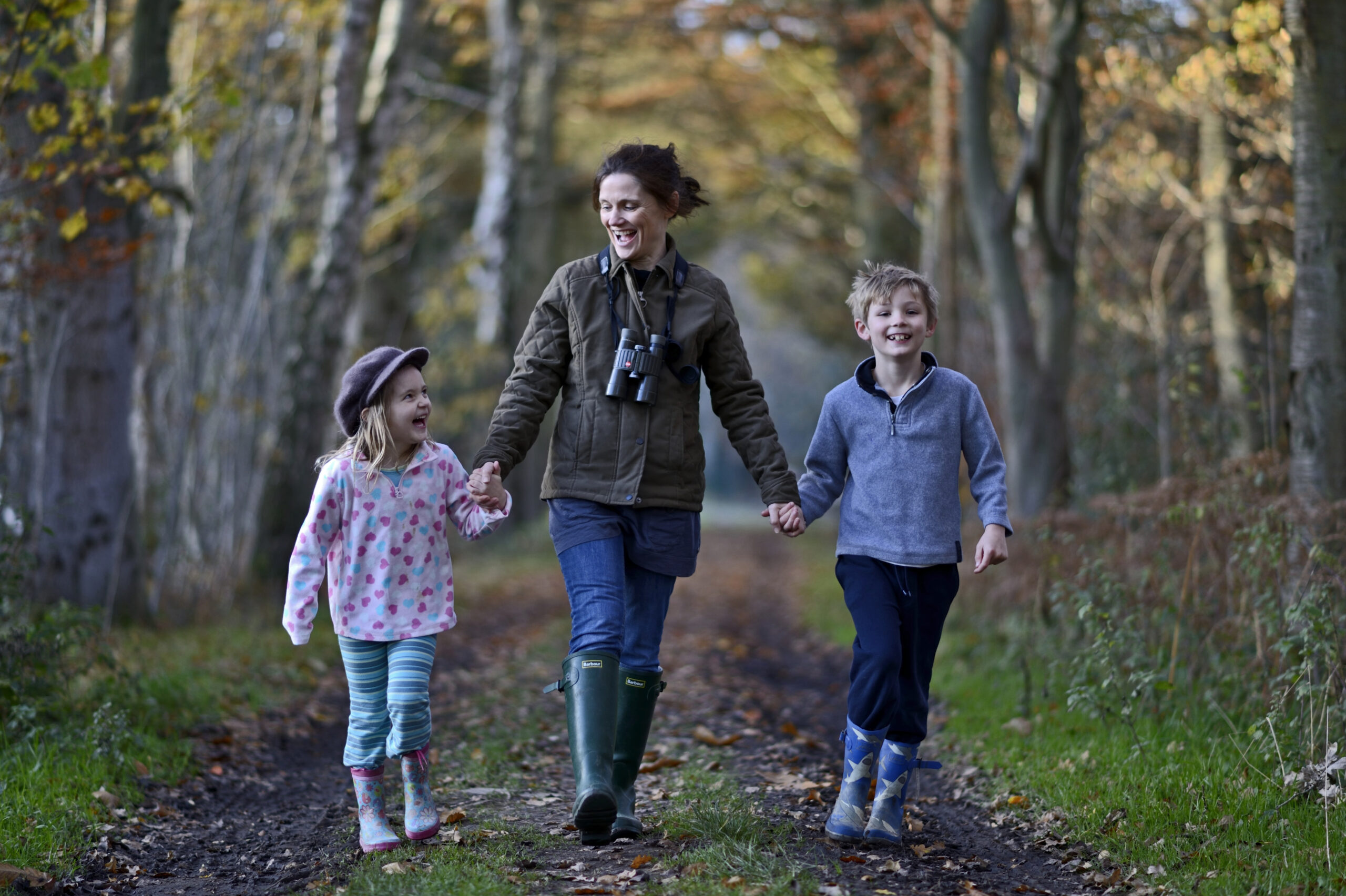 Mother, son and daughter on woodland walk in autumn, Norfolk, UK