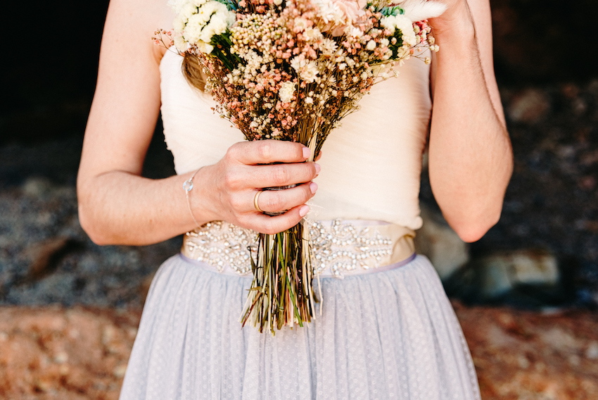 Bride with pink wedding dress holding her bouquet of flowers.