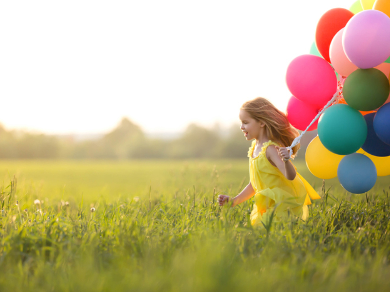 Little girl with balloons outdoors