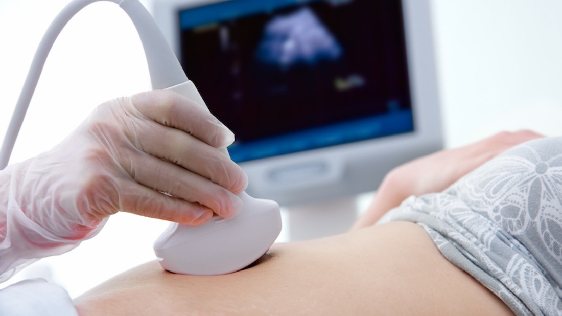 Pregnant woman getting ultrasound from doctor