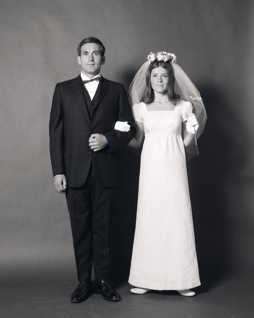 Full-Length Portrait Of Groom Arm-In-Arm With Bride With Daisy Veil.