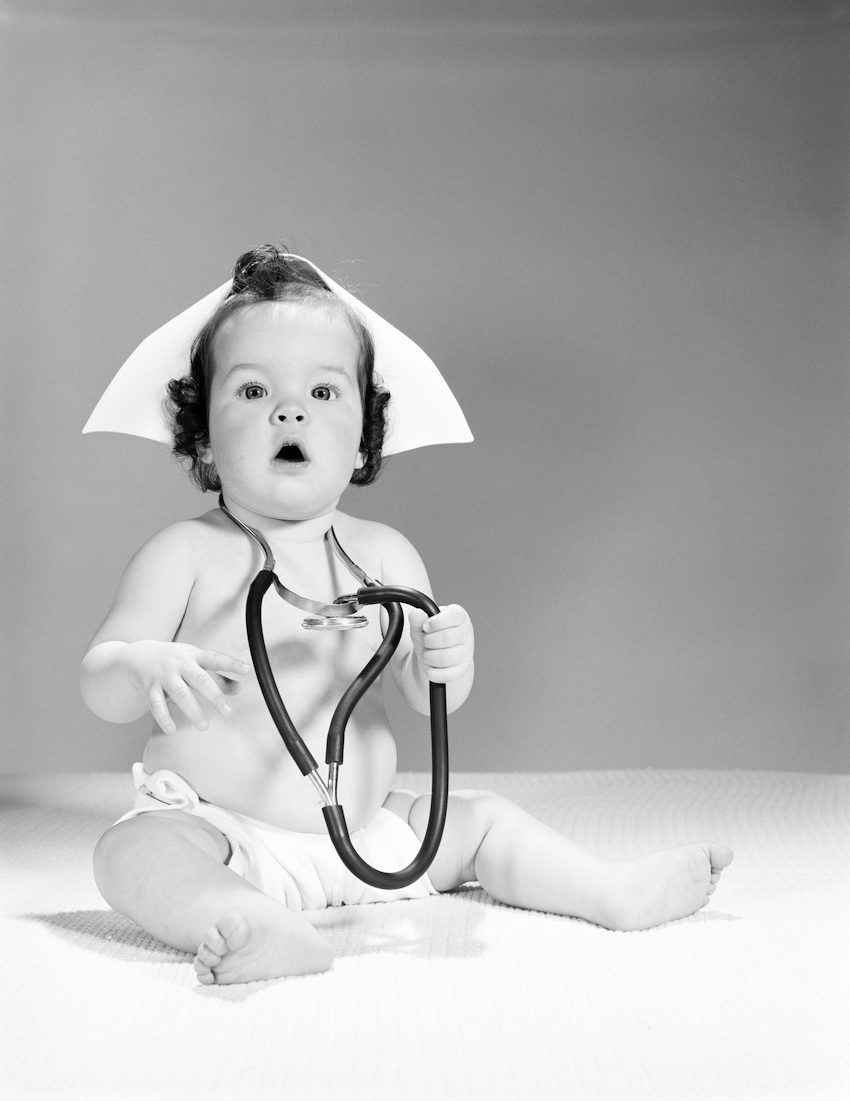 Baby wearing nurse's hat and stethoscope.