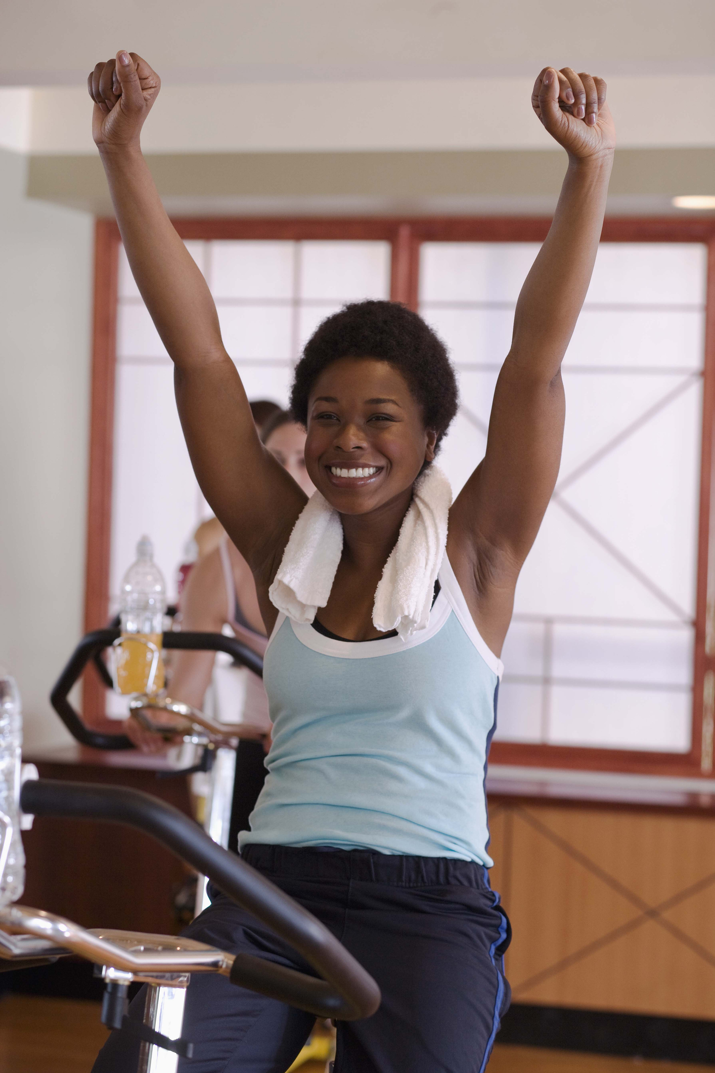 Happy woman with arms raised in exercise class