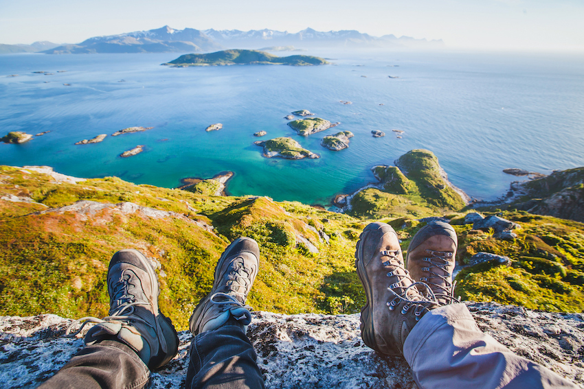 feet of people hikers relaxing on top of the mountain, travel background