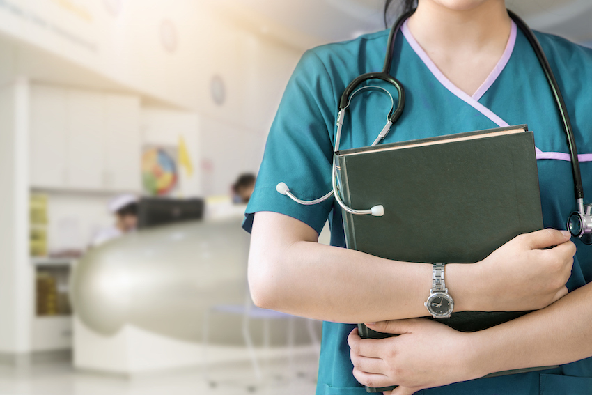 Cropped image of nurse holding green book on white background