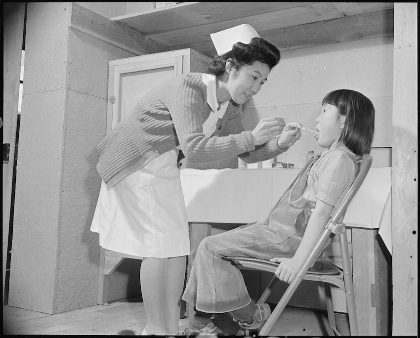 Granada_Relocation_Center_Amache_Colorado._The_school_nurse_administers_a_throat_swabbing_to_a_yo_._._._-_NARA_-_539052.jpg