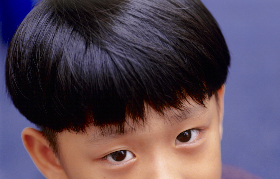 Young boy (6-7) with short black hair, close-up, portrait