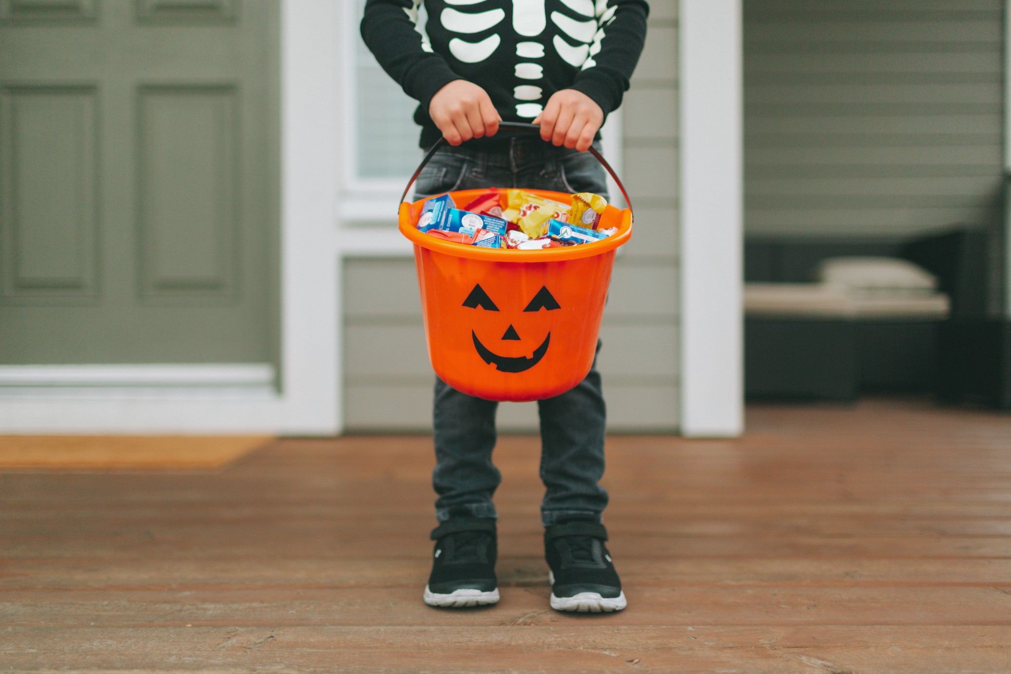 a-little-boy-holding-a-bucket-filled-with-halloween-candy_t20_a7Earx.jpg