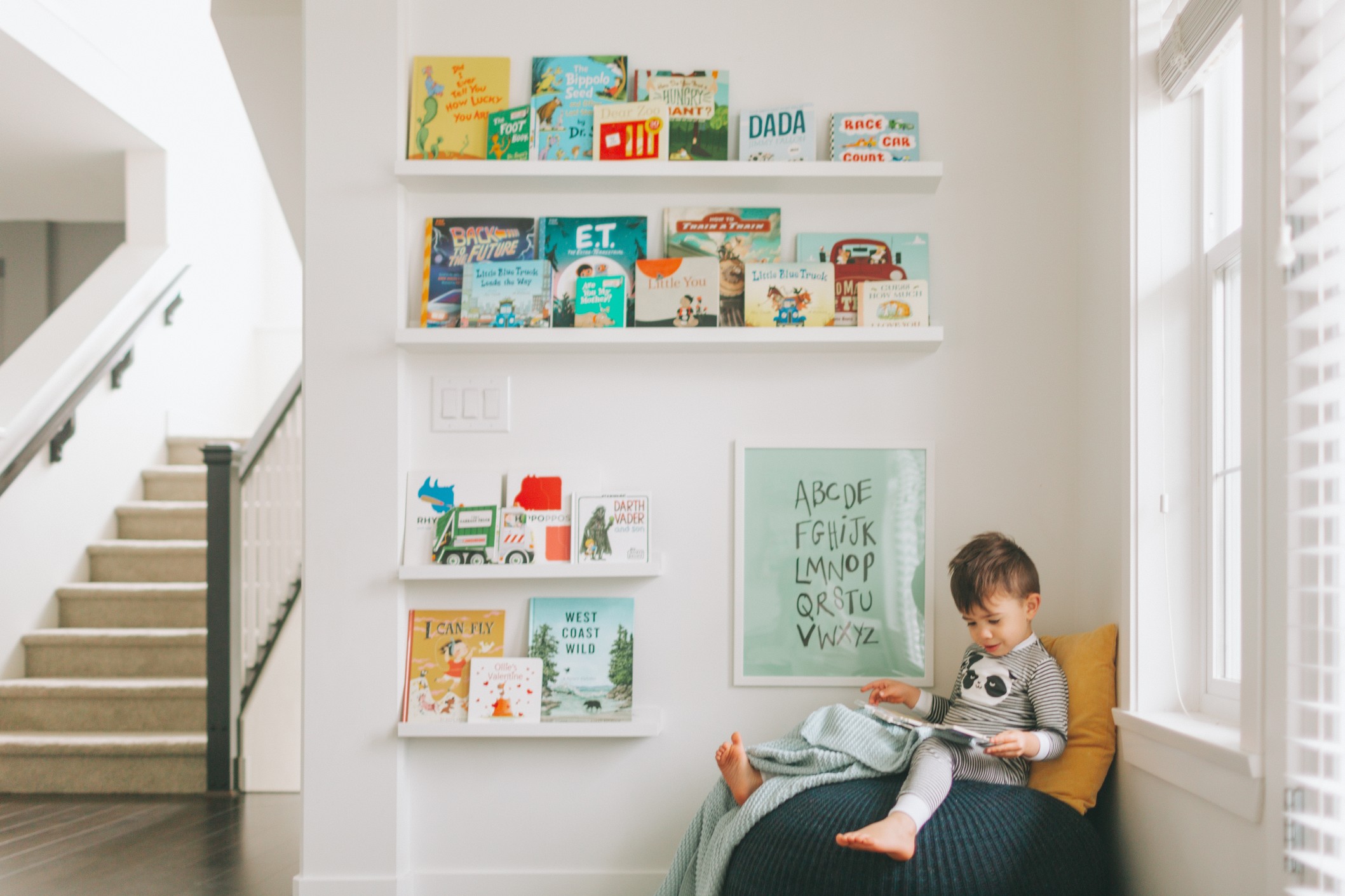 a-little-boy-reading-at-home-in-front-of-a-wall-of-books_t20_096xLV-1.jpg