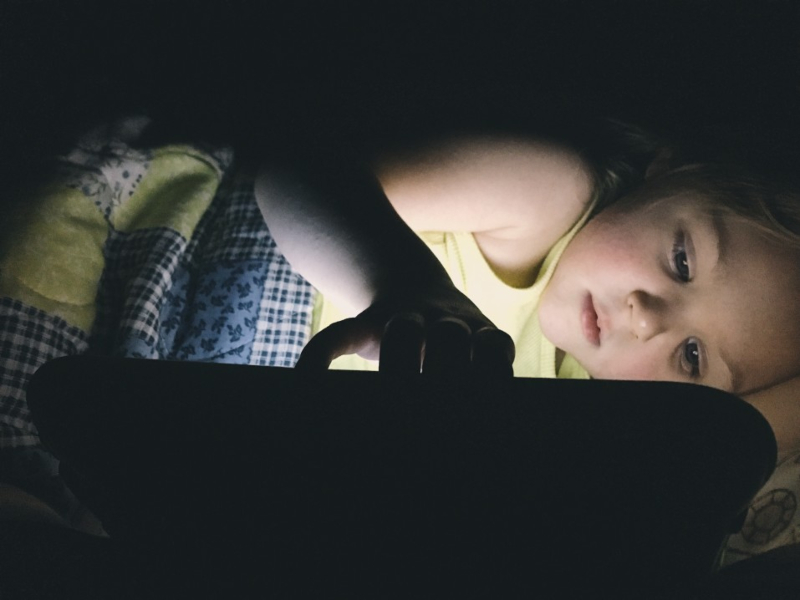 a-little-girl-plays-on-her-tablet-in-the-dark-while-laying-in-bed_t20_xvgQZ8-1.jpg