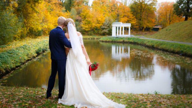 Wedding couple hugging by the lake in the fall