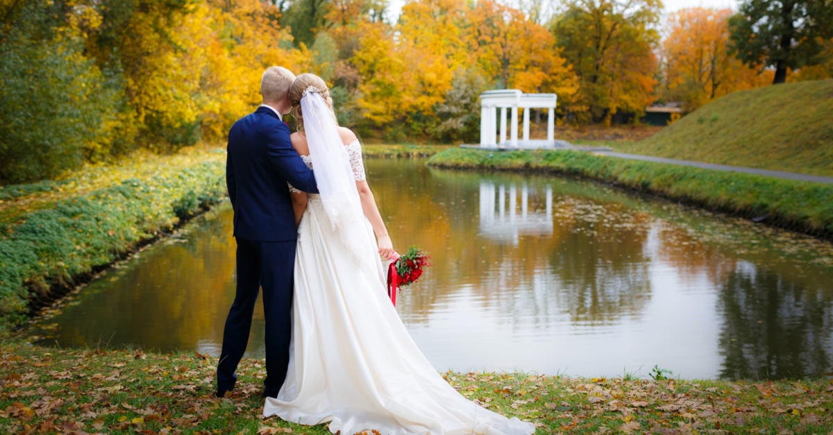 Wedding couple hugging by the lake in the fall