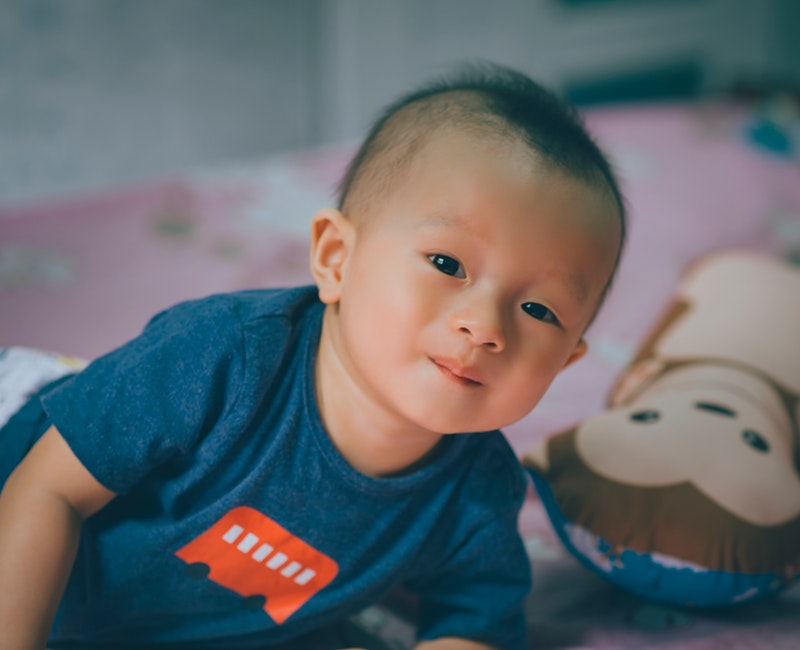 close-up-photography-of-baby-lying-on-the-bed-near-bolster-765251.jpg